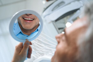 man looking at his new smile from Sarasota Periodontal Associates