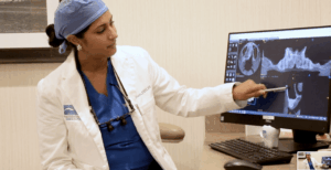 oral surgeon pointing to xrays on computer monitor