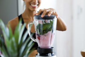 woman making smoothie in a blender
